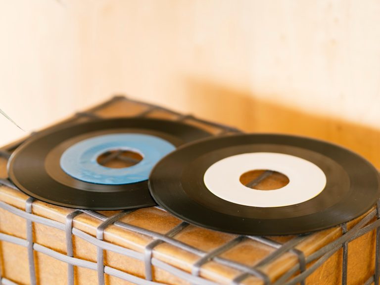 To vinylsingler ligger på en trekasse i varmt dagslys